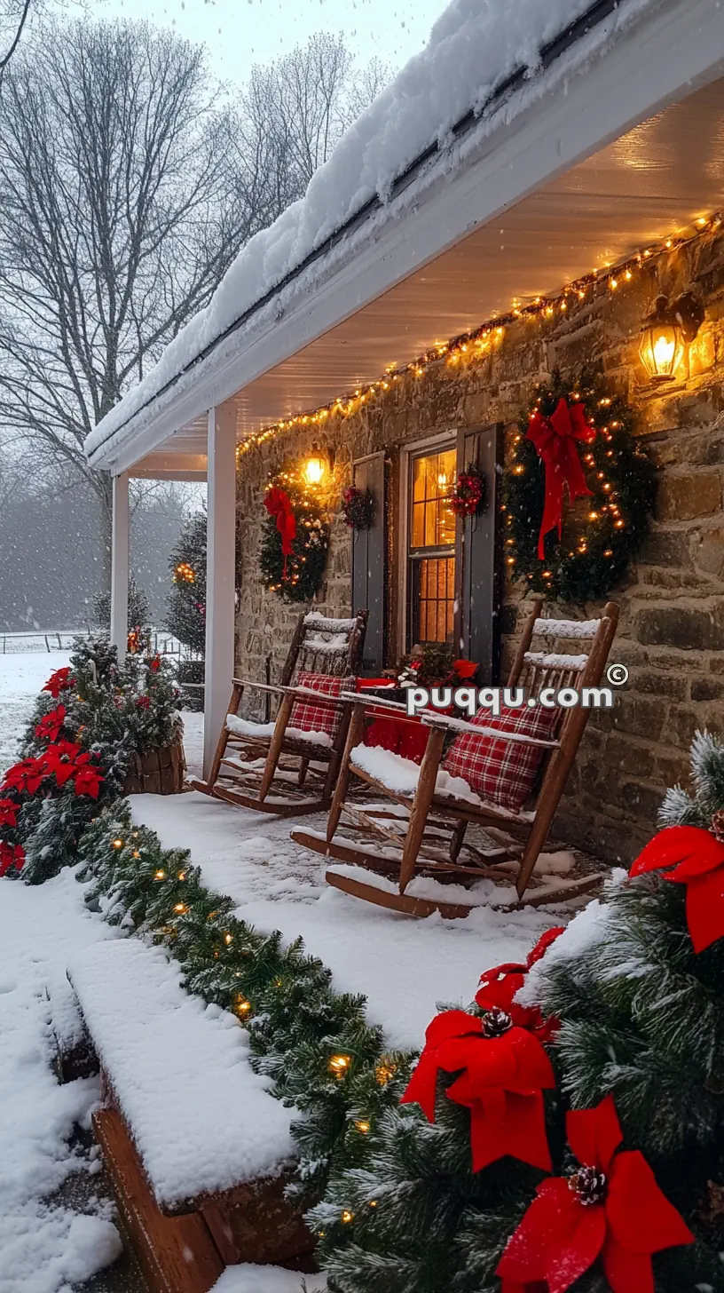 Snow-covered porch with rocking chairs, decorated with Christmas wreaths, garlands, and red ribbons, and warm glowing lights.