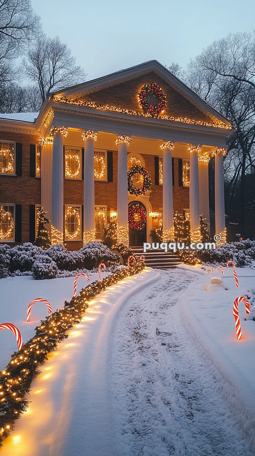 A large house adorned with Christmas lights, wreaths, and candy cane decorations in a snowy landscape.