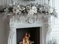 Elegant white fireplace decorated with a wreath, candles, silver ornaments, and snowy greenery.