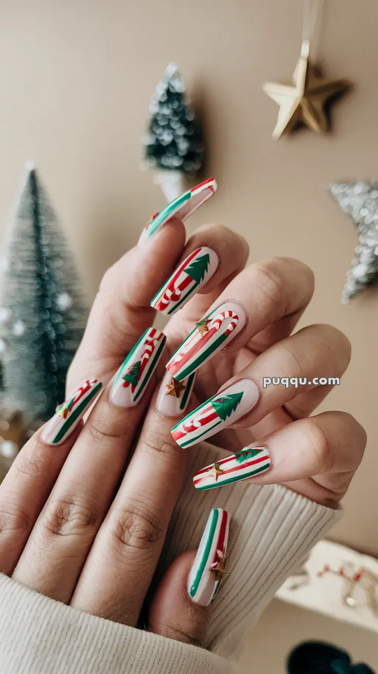 Fingers with long nails featuring festive Christmas designs, including candy canes and Christmas trees.