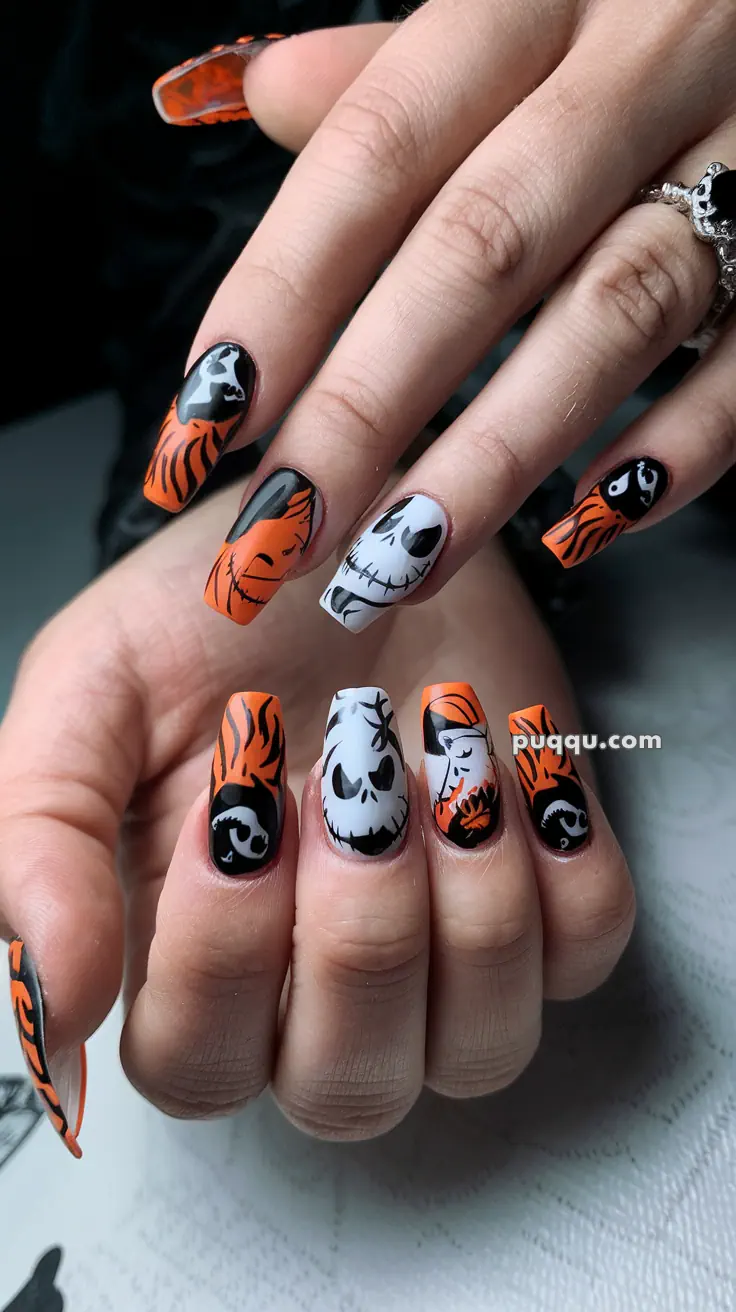 Halloween-themed nail art with orange, black, and white designs featuring skulls and swirls.