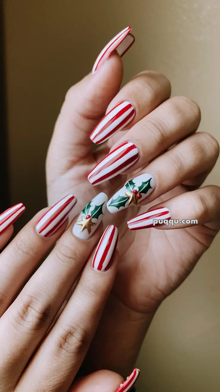 Hands with long nails featuring red and white candy cane stripes, and holly decorations on two accent nails.