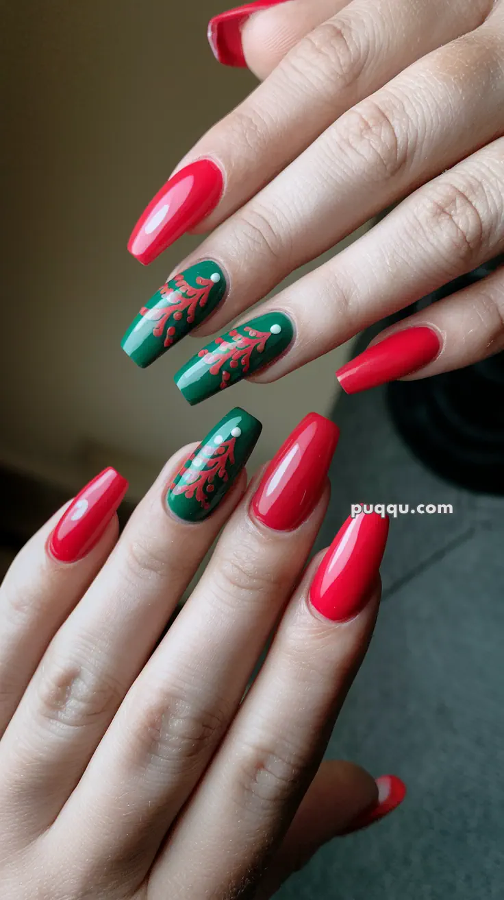 Fingernails with a red polish and green accent nails featuring red floral designs.