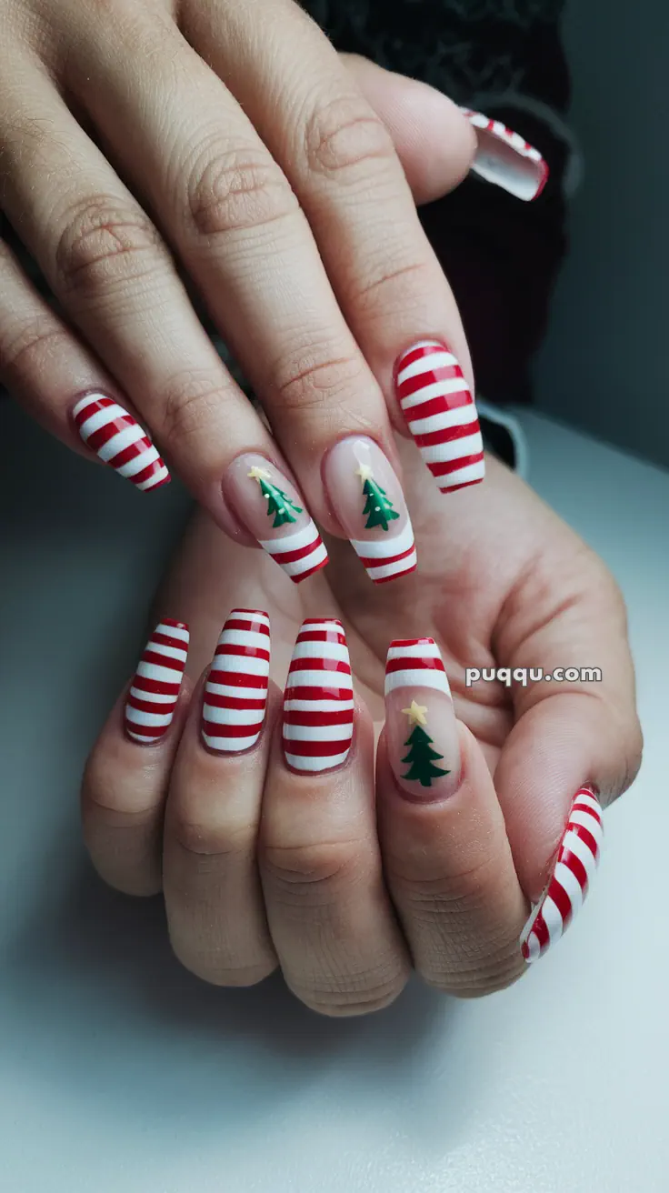 Red and white striped nails with Christmas tree designs.