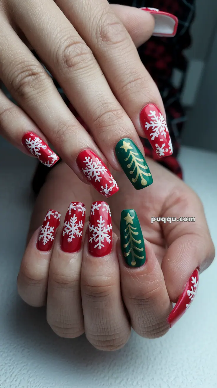 Festive nails with red and green polish featuring white snowflakes and gold Christmas tree designs.