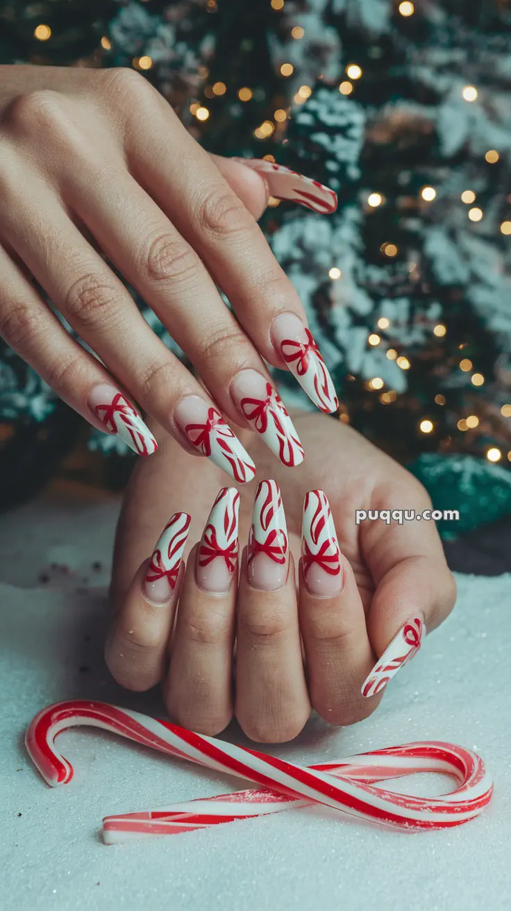 Festive nails with red and white candy cane design, with candy canes in the background.