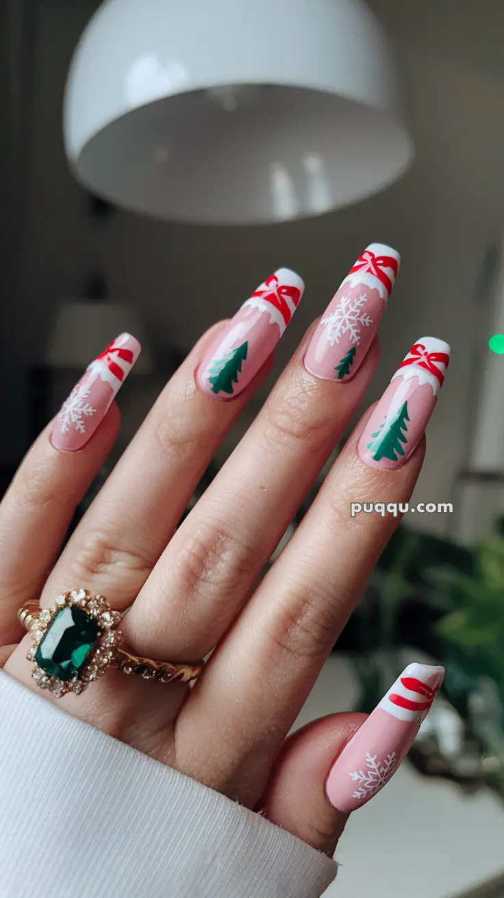 Festive nail art with snowflakes, Christmas trees, and red ribbons, featuring a ring with a large green gemstone.