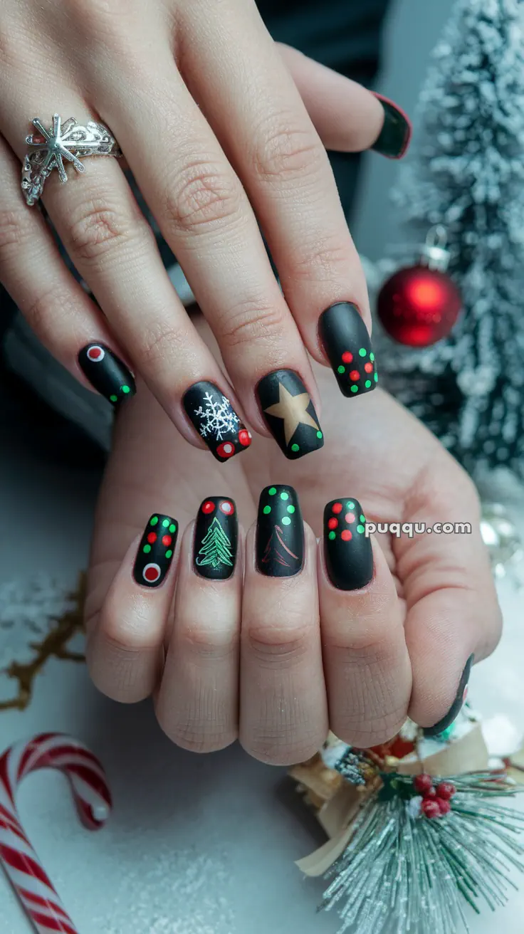 Hands with Christmas-themed black matte nail art, featuring designs like snowflakes, stars, Christmas trees, and colorful dots, against a festive background.