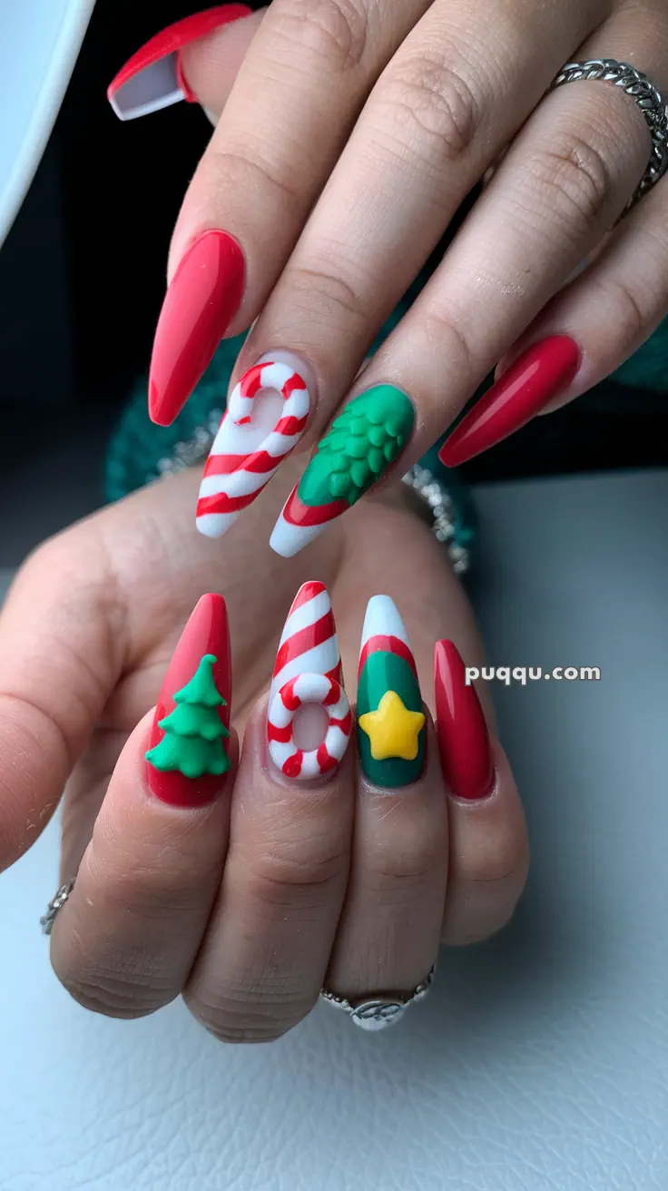 Close-up of festive nail art featuring red and green designs with 3D candy canes, Christmas trees, and a star.