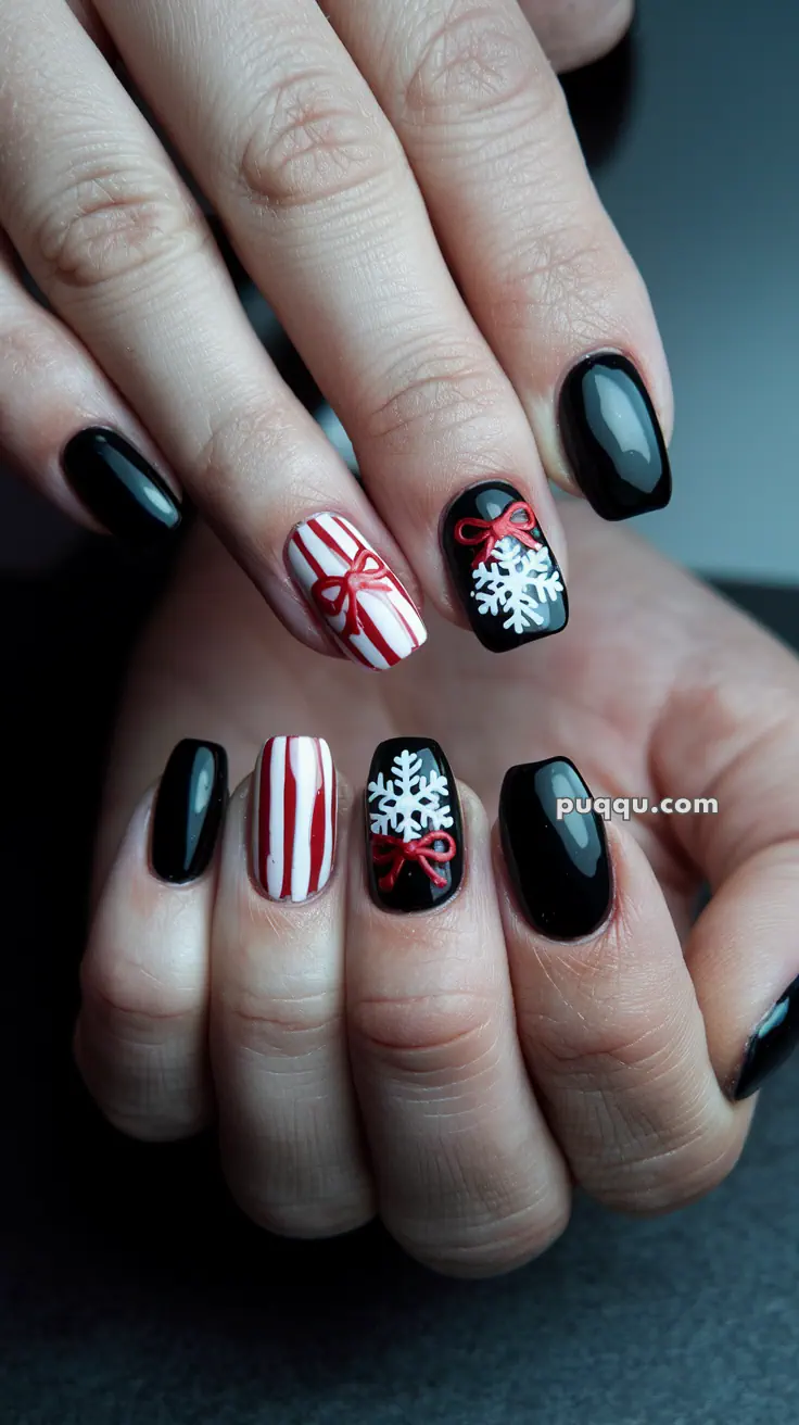 Fingernails painted with black, red, and white holiday-themed designs, featuring snowflakes, stripes, and bows.