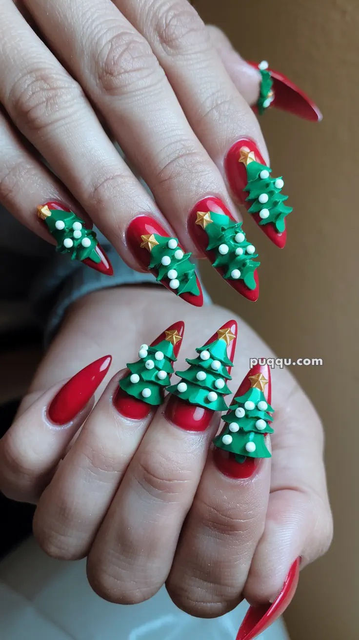 Red nails with 3D green Christmas tree decorations and white bead ornaments.