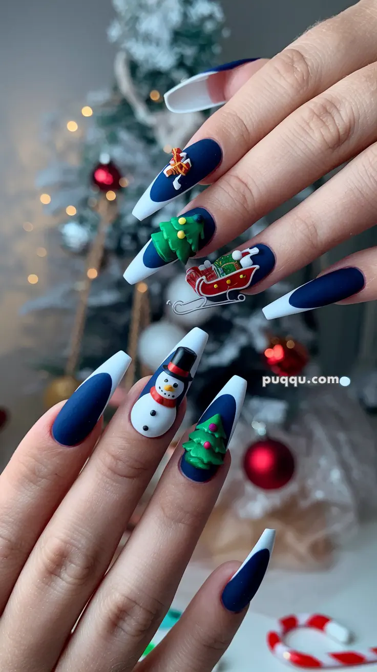 Blue and white festive nails with 3D Christmas designs including a snowman, Christmas tree, and sleigh.