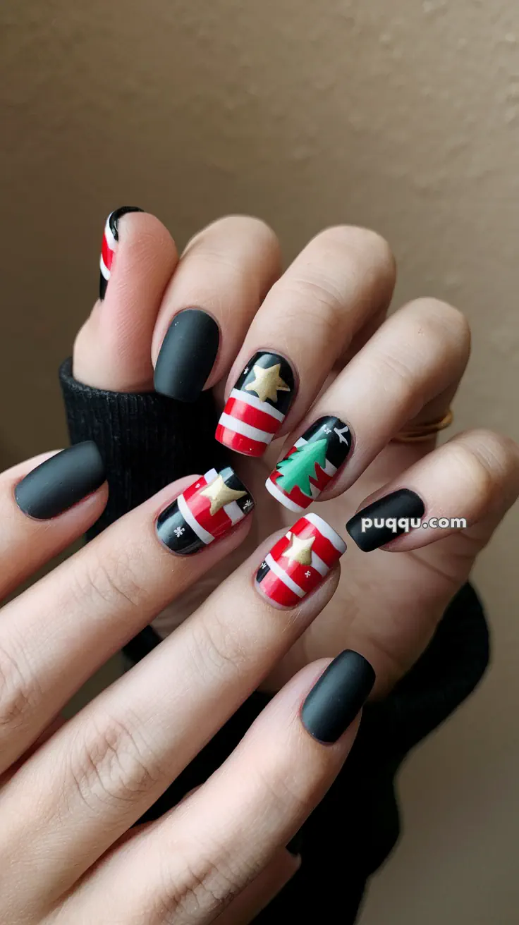 Festive matte black and red nail art with Christmas-themed designs, including stars and a tree.