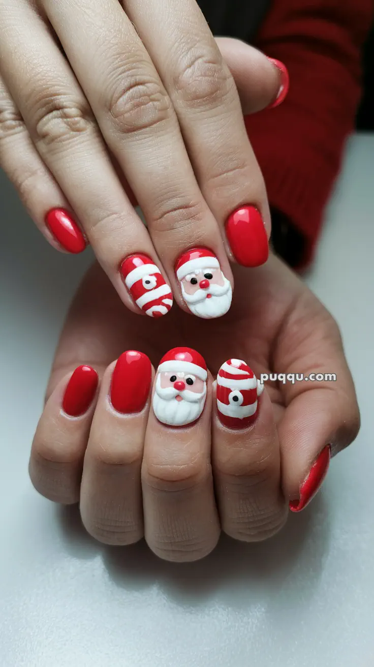 Red Christmas-themed nail art with Santa Claus designs and candy cane stripes.