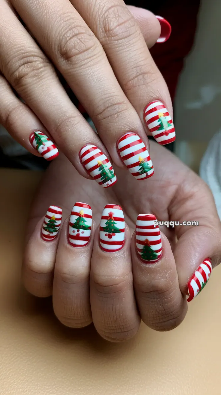 Fingernails with striped red and white Christmas-themed nail art featuring Christmas trees.