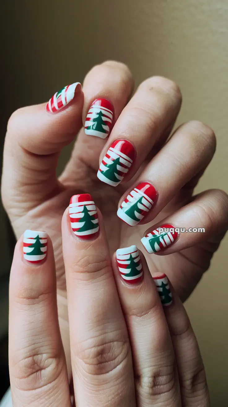 Hands with red, white, and green Christmas-themed striped nail art featuring tree designs.