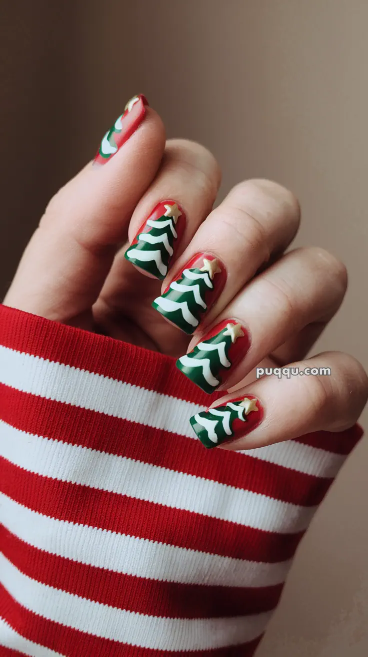 Fingernails with Christmas tree nail art and a red and white striped sleeve.