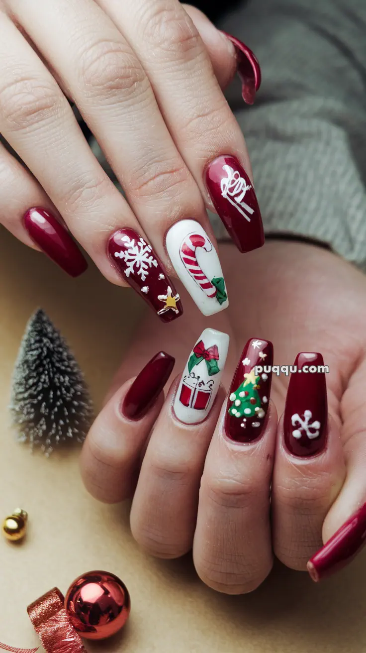 Red and white Christmas-themed nail art with designs of snowflakes, a candy cane, a gift, and a Christmas tree.