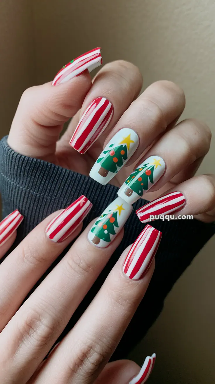 Long nails with red and white candy cane stripes, featuring Christmas tree designs on two nails.