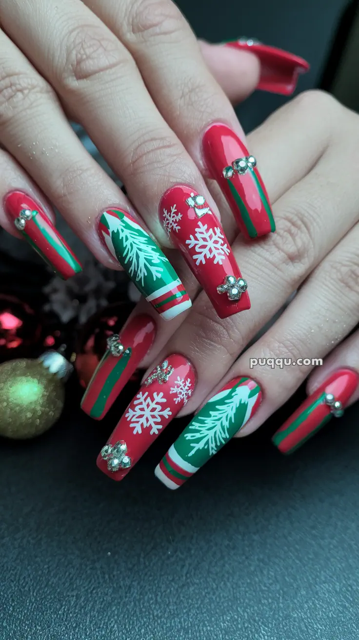 Festive red and green nails with snowflakes, pine branches, and rhinestone decorations.