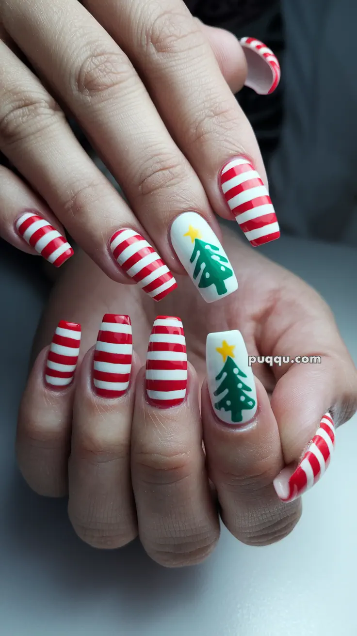 Fingernails with red and white striped designs, featuring two nails with a green Christmas tree and a yellow star on a white background.