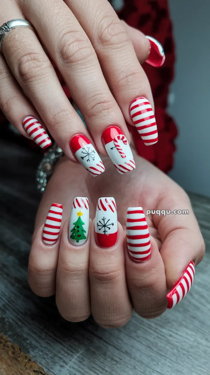 Festive nail art with red and white candy cane stripes, a snowflake, a candy cane, and a Christmas tree design.