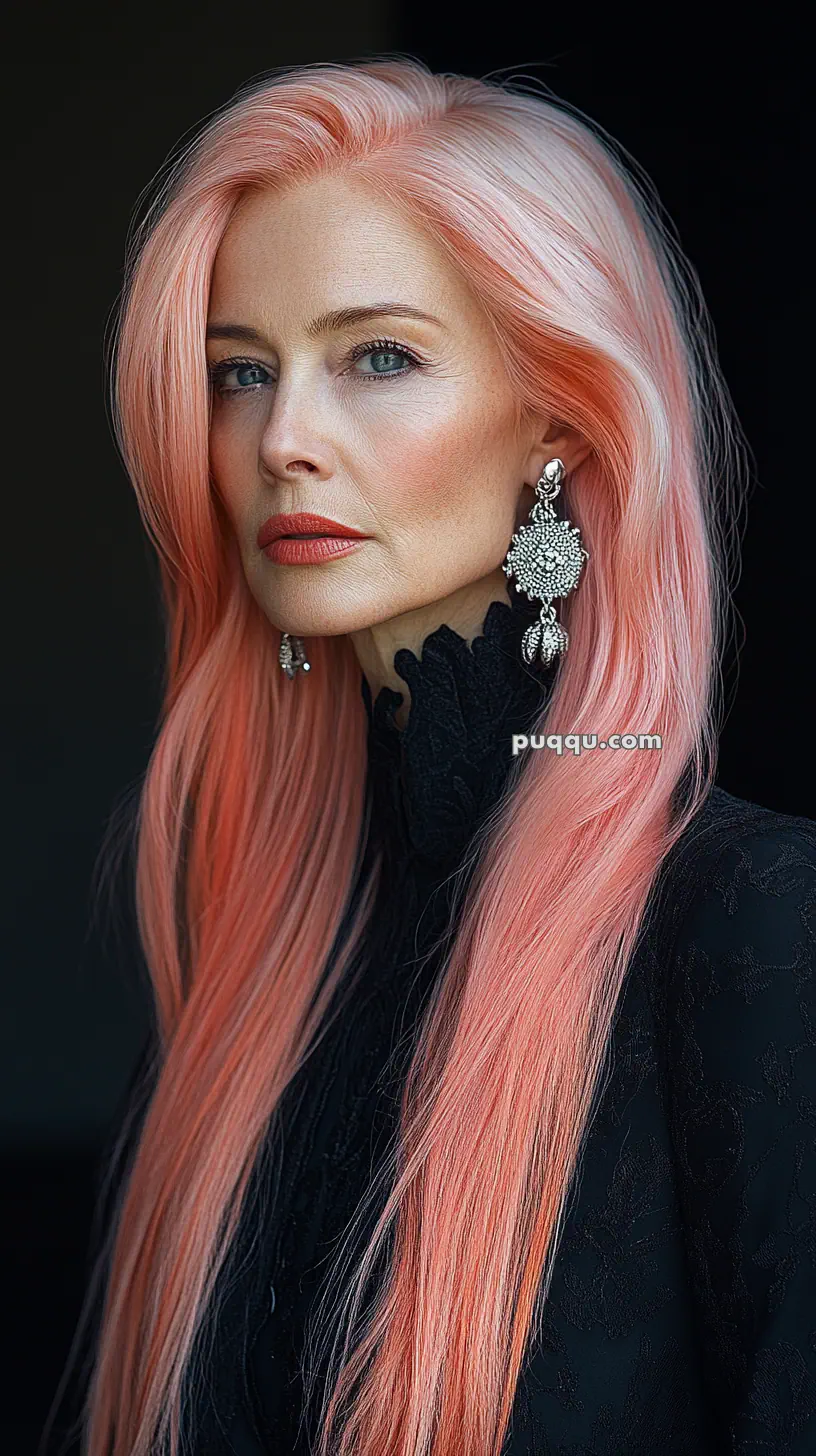 Portrait of a woman with long pink hair, wearing ornate earrings and a black outfit.