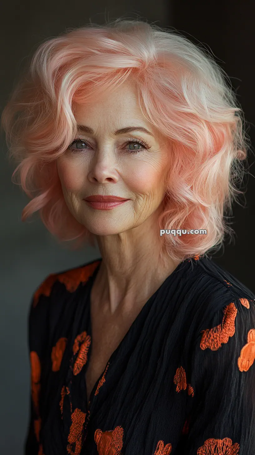 Elderly woman with wavy pink hair and a black dress with orange patterns.