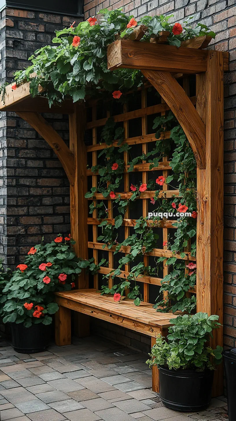 Wooden trellis bench with climbing plants and red flowers against a brick wall.