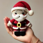 A hand holding a small crochet Santa Claus toy.