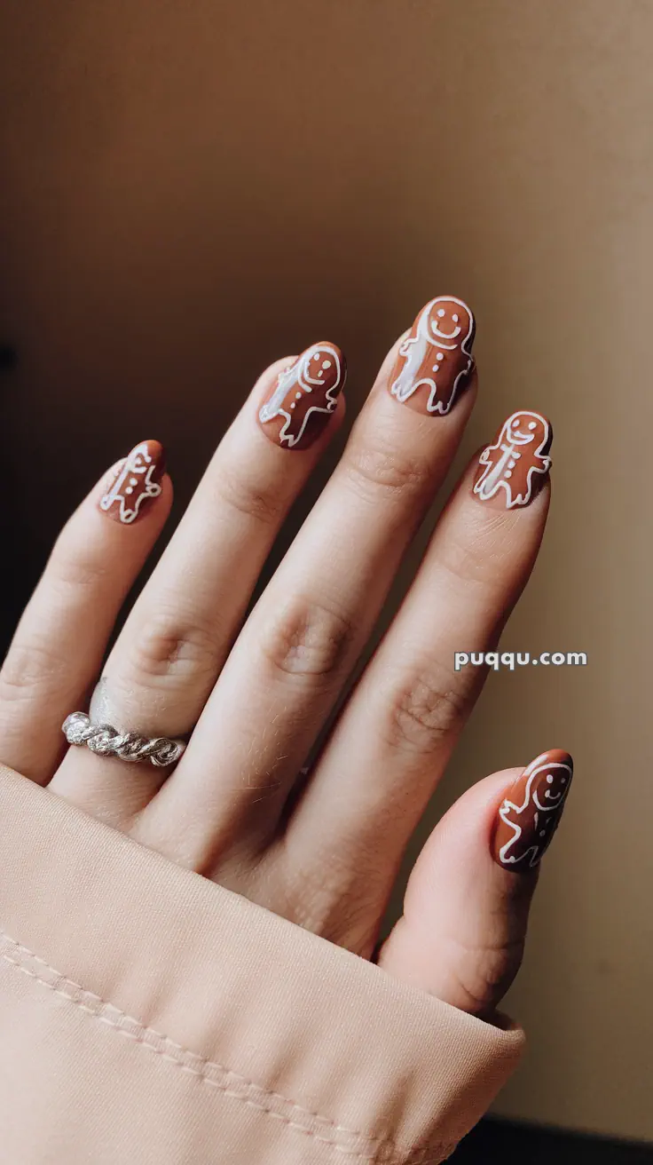 Hand with gingerbread man nail art design.