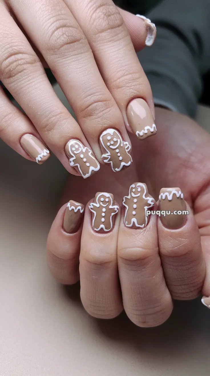 Nude nails with white and brown gingerbread man designs and icing-like tips.