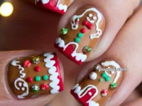 Close-up of festive nail art featuring gingerbread men designs with colorful accents and detailing.