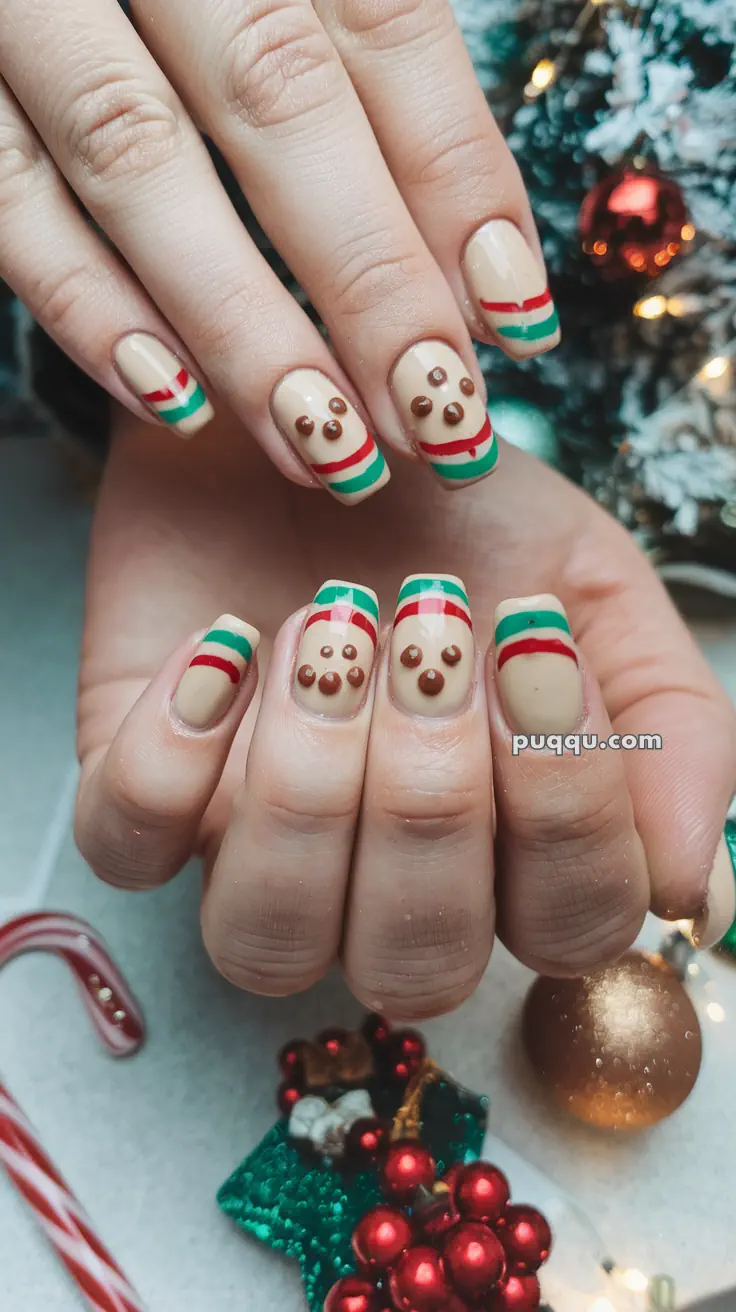 Festive nail art with gingerbread men and green and red striped designs.