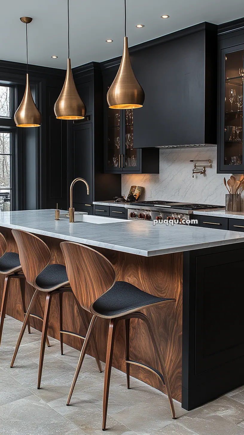 Modern kitchen with a marble countertop island, three wooden chairs, black cabinets, and brass pendant lights.