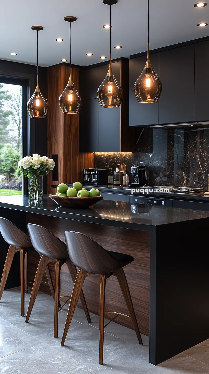 Modern kitchen with dark cabinets, wooden accents, island with bar stools, pendant lighting, and a bowl of green apples.