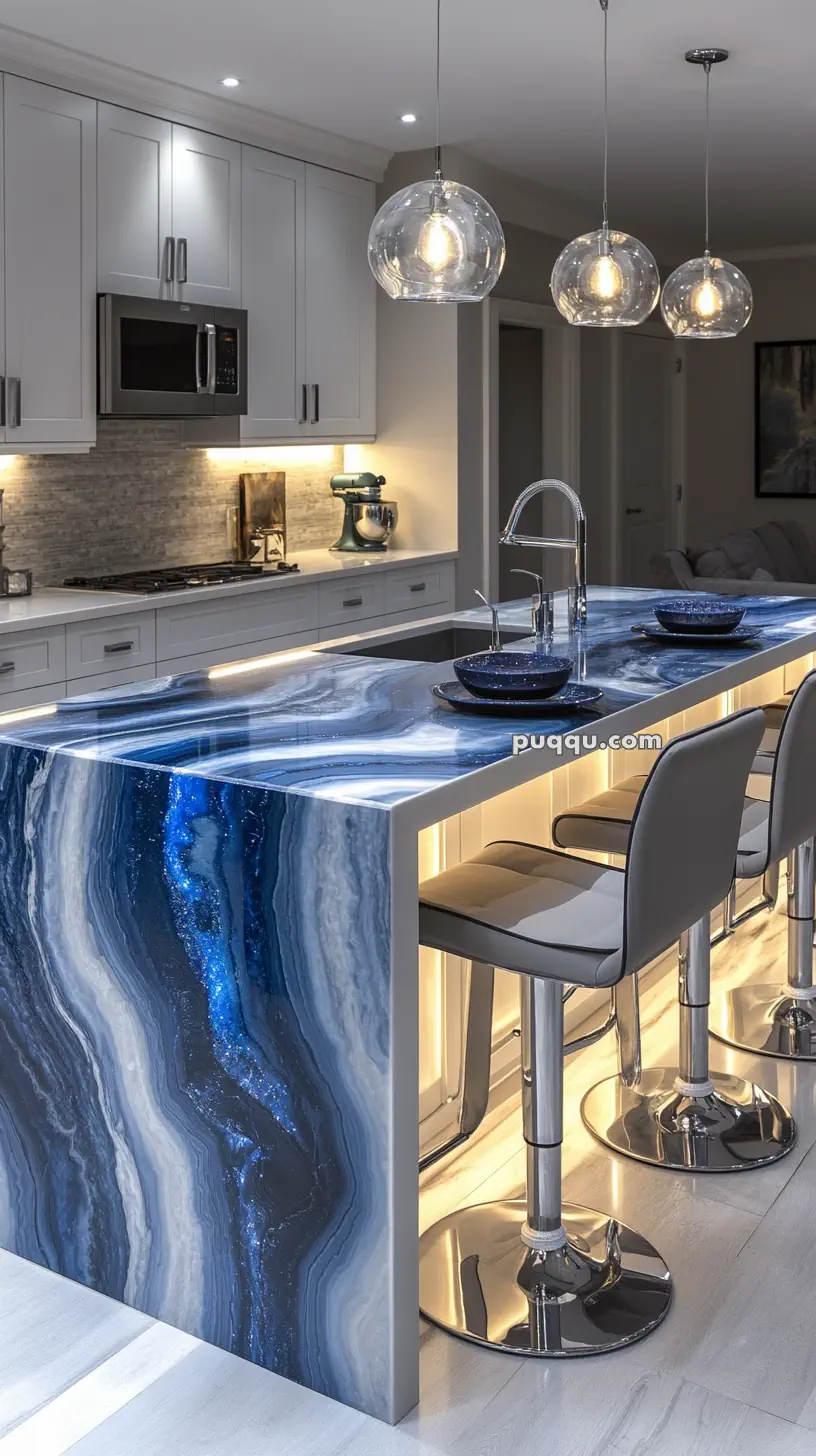 Modern kitchen with a striking blue marbled island countertop, three bar stools, pendant lights, and white cabinets.