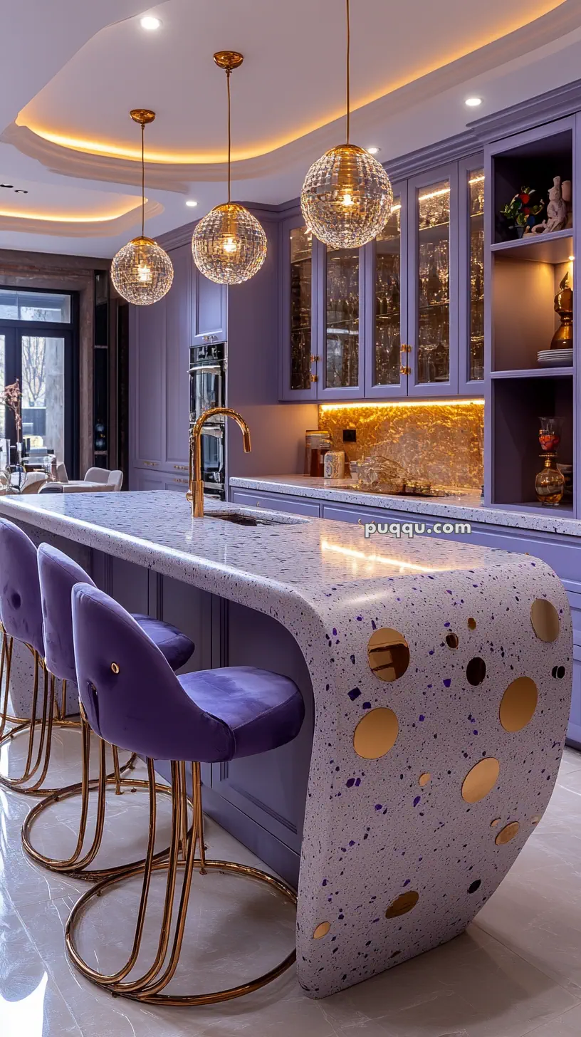 Modern kitchen with a curved speckled countertop, purple cabinetry and barstools, gold accents, and spherical pendant lighting.