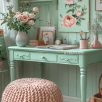 A pastel-themed room with a mint green desk, pink floral decor, and a chunky knit pouf.