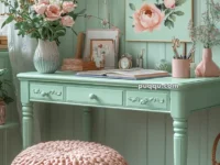 A pastel-themed room with a mint green desk, pink floral decor, and a chunky knit pouf.