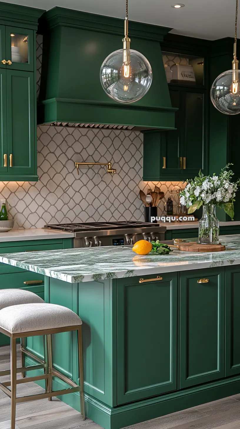 Elegant kitchen with green cabinets, marble countertops, pendant lights, and a floral arrangement.