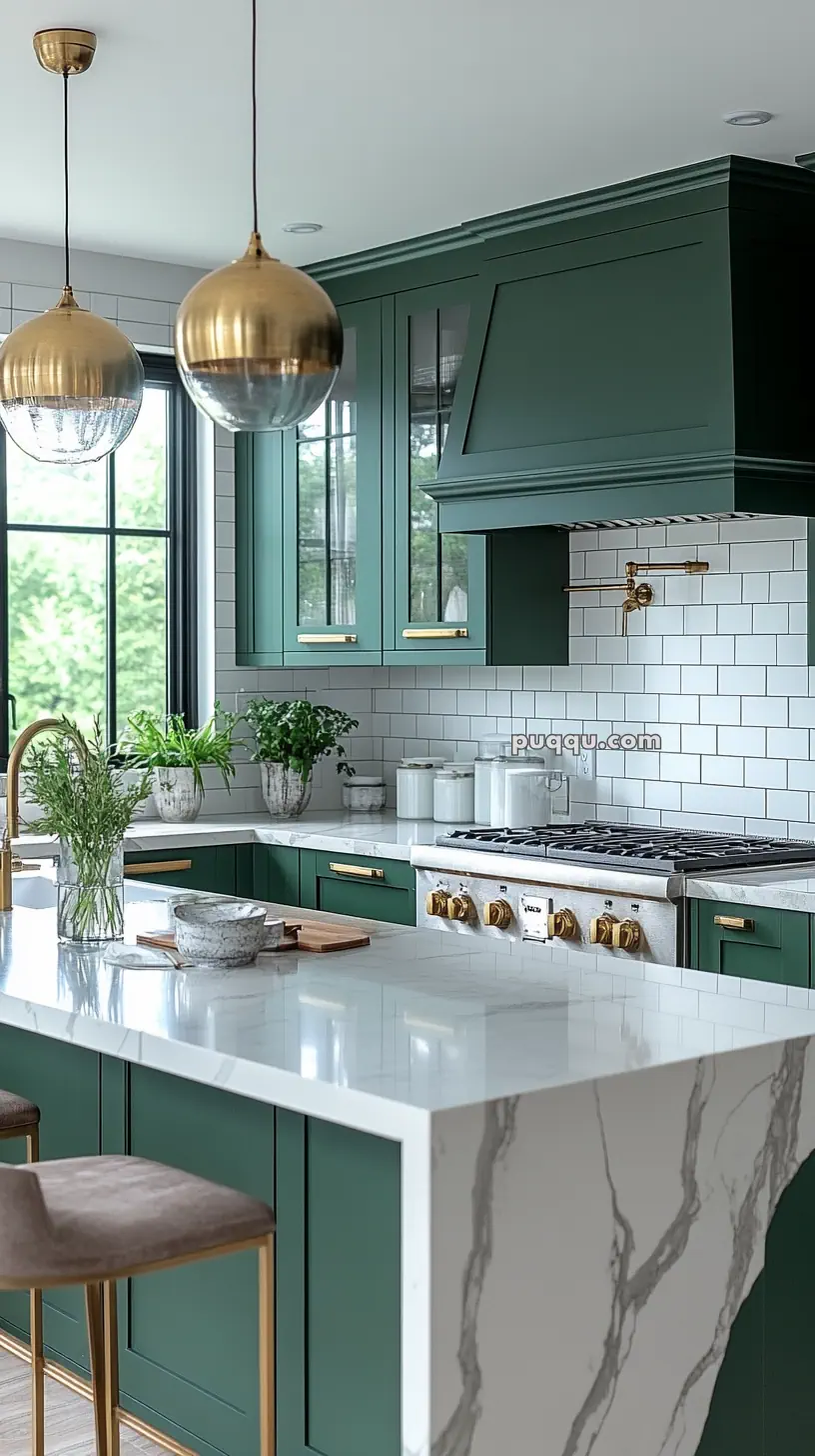 Modern kitchen with green cabinets, white subway tile backsplash, marble countertops, brass fixtures, and pendant lighting.