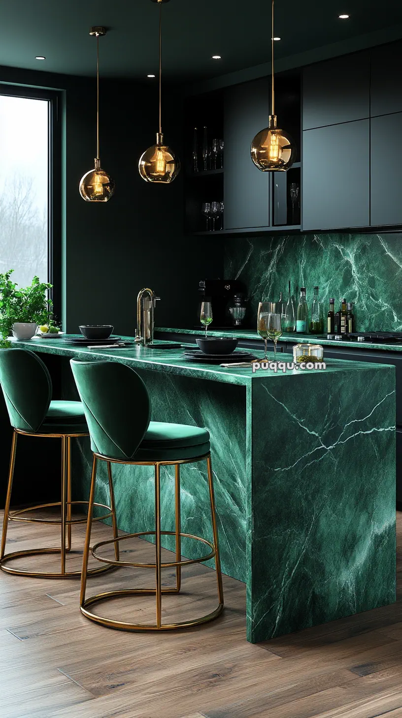 Modern kitchen with green marble countertops, green velvet bar stools with gold legs, wooden floor, and hanging glass pendant lights.