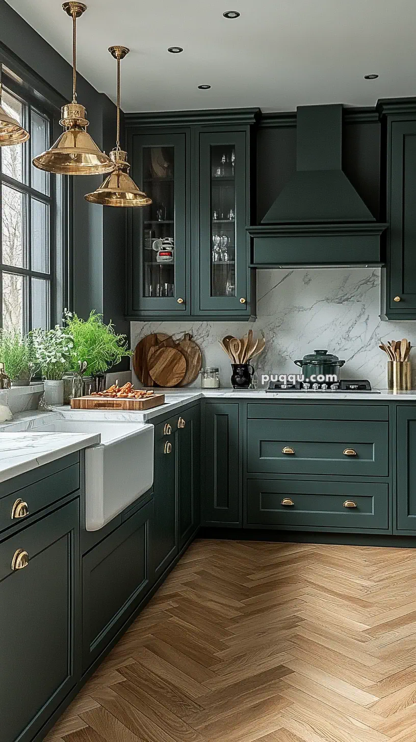 Stylish kitchen with dark green cabinets, marble countertops, brass hardware, wooden cutting boards, and decorative plants.