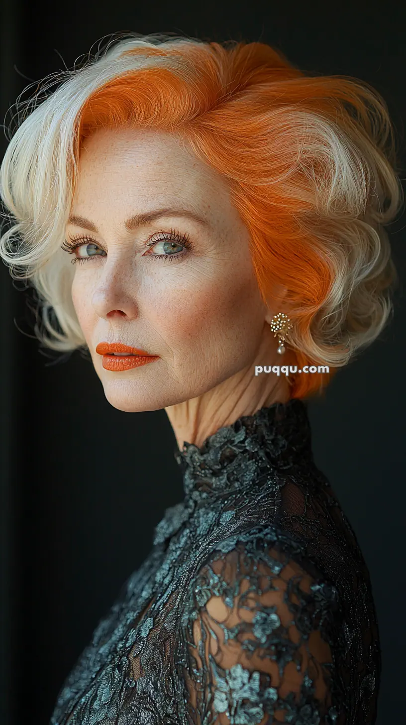 Elderly woman with orange and white hair, wearing a lace top and pearl earring.