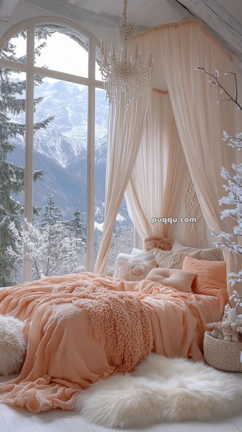 Cozy bedroom with peach bedding, large windows showing snow-covered mountains, a crystal chandelier, and soft, warm lighting.