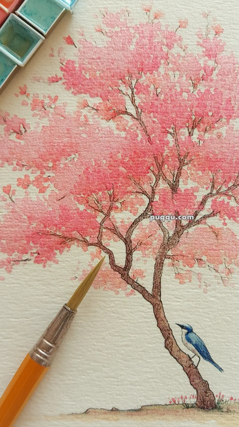 A watercolor painting featuring a cherry blossom tree with pink flowers and a small blue bird perched on its trunk. A paintbrush and watercolor palette are visible on the side, suggesting the painting's creation process.
