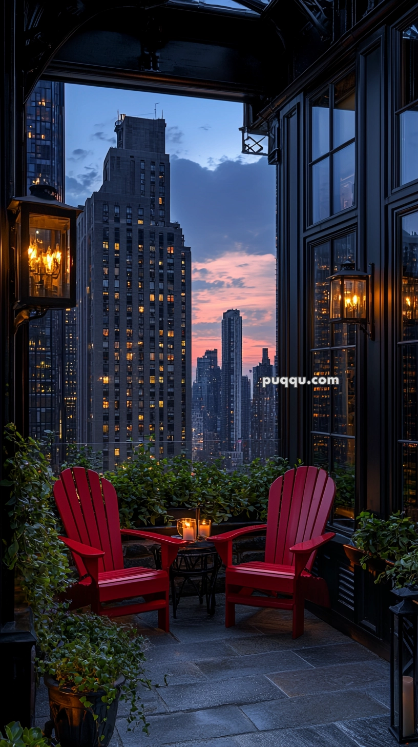 A rooftop terrace with two red chairs and a small table with candles, surrounded by plants, overlooking a city skyline at dusk with illuminated skyscrapers and a colorful sky.