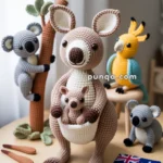 Crocheted kangaroo with a joey, surrounded by crocheted animals including koalas and a cockatoo, on a tabletop featuring a small Australian flag and trees.