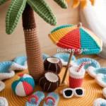 Colorful crochet scene depicting a beach setting with a palm tree, sun, umbrella, beach ball, coconut drinks, flip-flops, sunglasses, and a drink with a straw on a yellow and blue base.